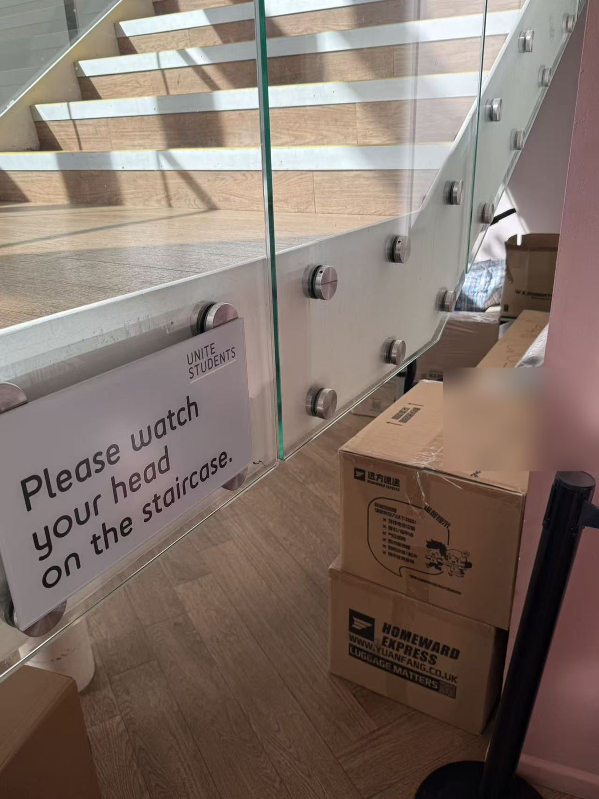 Two Homeward Express boxes left beside the stairs in a building's reception.