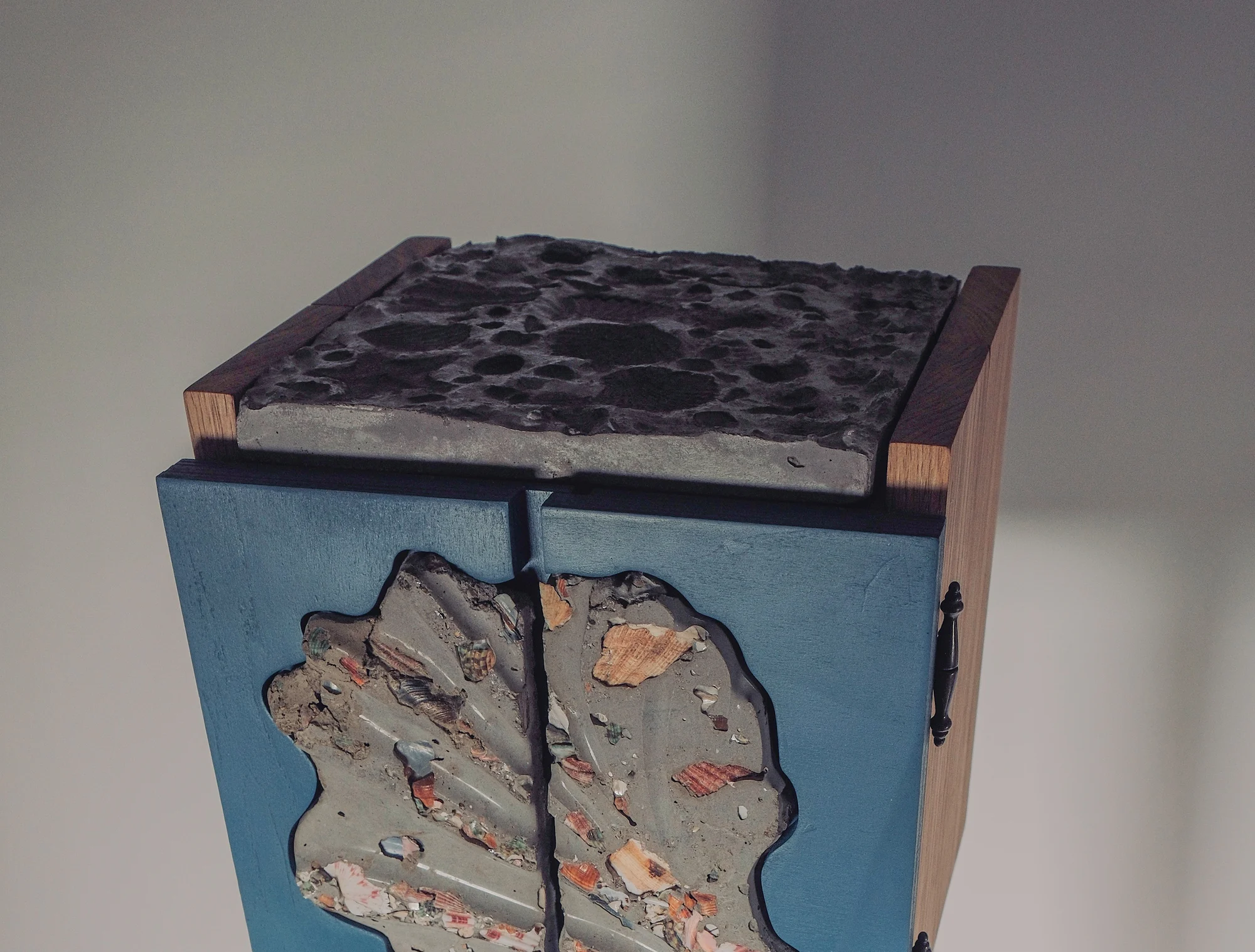 Concrete top with shell imprints above the split shell tile on the blue doors