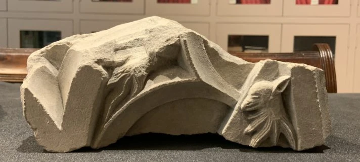 The carved stone fragment on a table in the museum